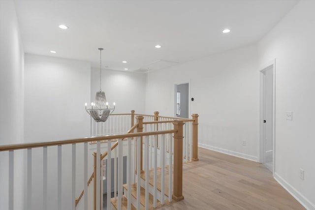 hallway with light hardwood / wood-style floors and a chandelier