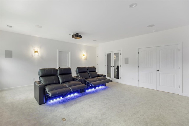 cinema featuring french doors and light colored carpet