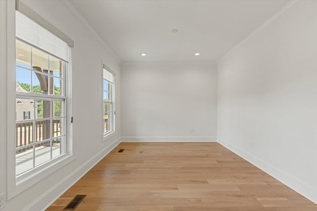 empty room with light wood-type flooring and crown molding