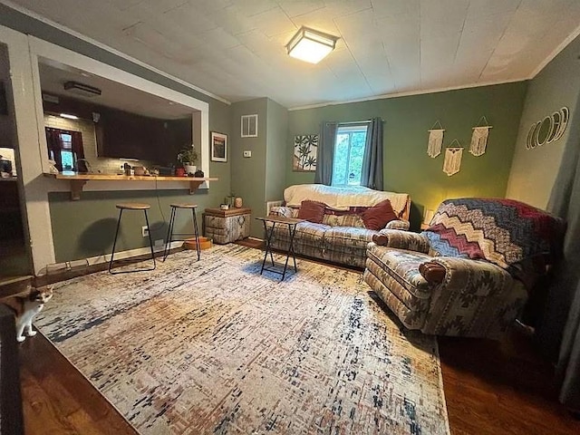 living room featuring hardwood / wood-style floors and crown molding