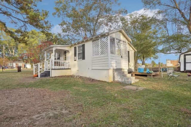 view of side of property with a lawn and a porch