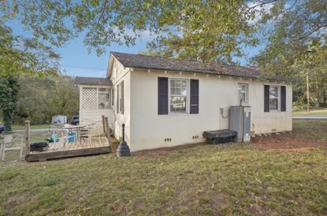 back of property featuring a yard and a wooden deck