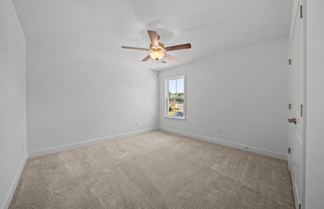 empty room with ceiling fan and light carpet