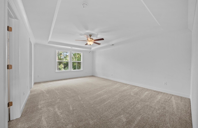 unfurnished room featuring light carpet, a raised ceiling, and ceiling fan