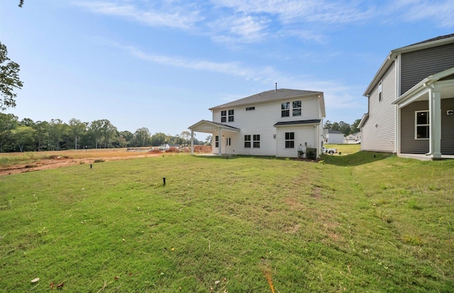 rear view of property featuring a lawn