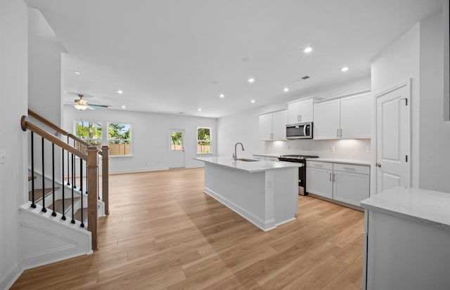 kitchen with white cabinetry, ceiling fan, stainless steel appliances, and light hardwood / wood-style floors