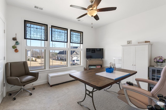 carpeted office space with ceiling fan