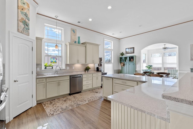 kitchen featuring ceiling fan, stainless steel dishwasher, cream cabinets, decorative backsplash, and light wood-type flooring