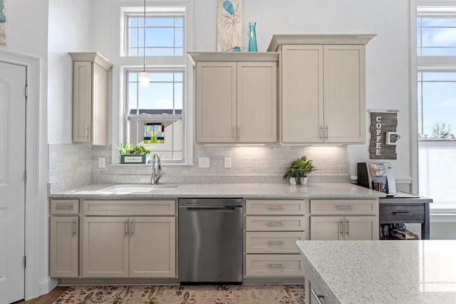 kitchen with backsplash, light stone countertops, sink, and stainless steel dishwasher