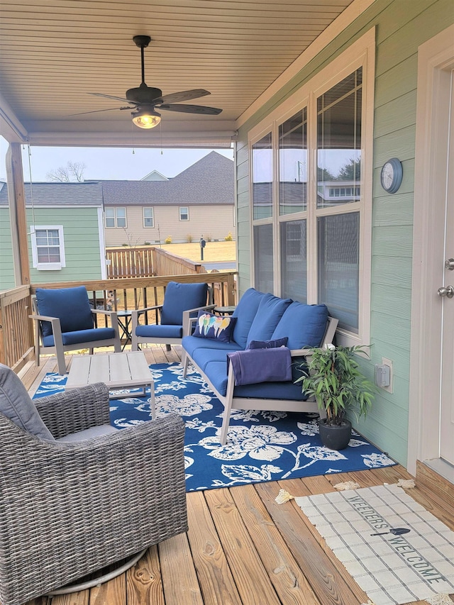 wooden terrace with an outdoor living space and ceiling fan