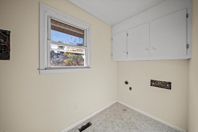 clothes washing area with cabinets