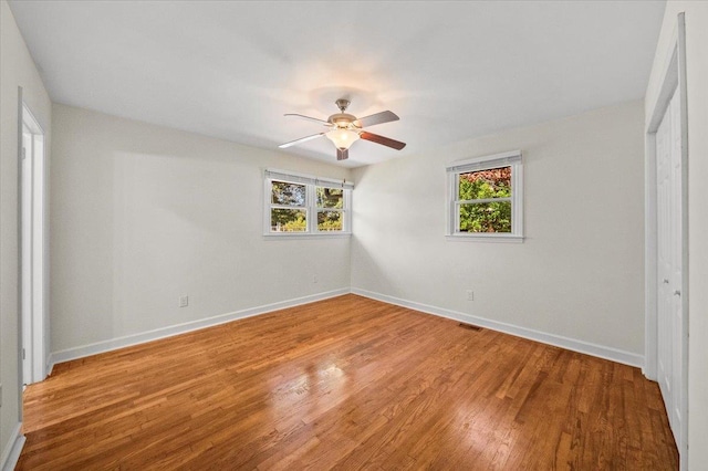 unfurnished bedroom featuring hardwood / wood-style floors, a closet, and ceiling fan