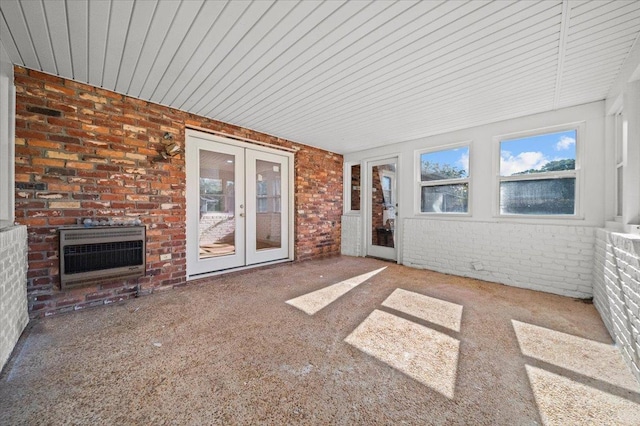 unfurnished sunroom featuring heating unit, french doors, and a fireplace