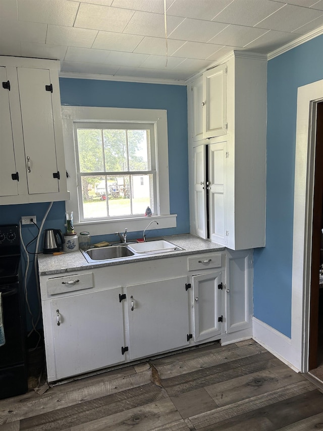 kitchen featuring dark hardwood / wood-style flooring, black electric range, crown molding, sink, and white cabinets