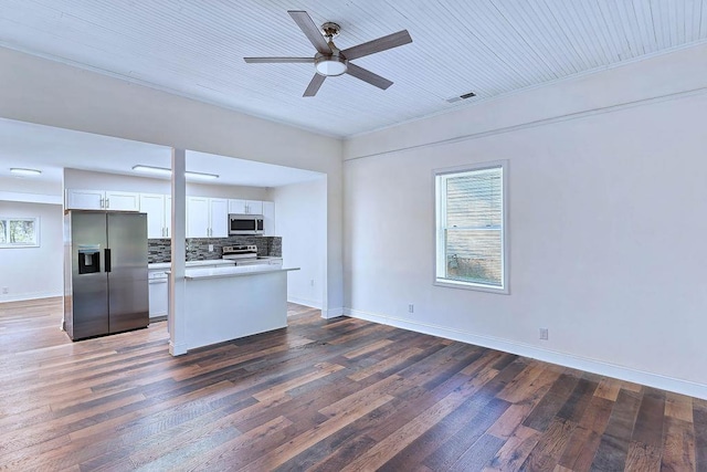 kitchen with white cabinetry, ceiling fan, dark hardwood / wood-style flooring, backsplash, and appliances with stainless steel finishes