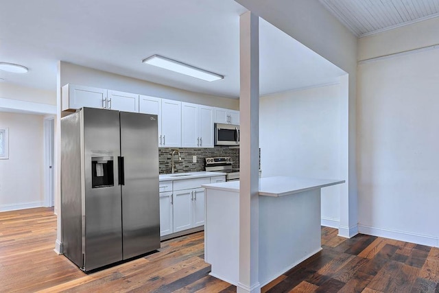 kitchen with dark hardwood / wood-style flooring, stainless steel appliances, sink, a center island, and white cabinetry