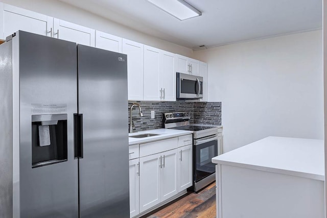 kitchen with sink, stainless steel appliances, dark hardwood / wood-style floors, decorative backsplash, and white cabinets