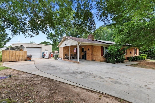 ranch-style home with solar panels, an outbuilding, and a garage