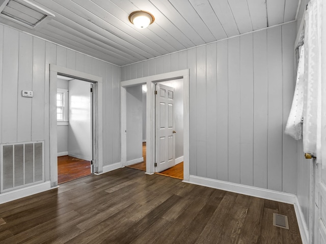 unfurnished room featuring dark wood-type flooring and wood ceiling