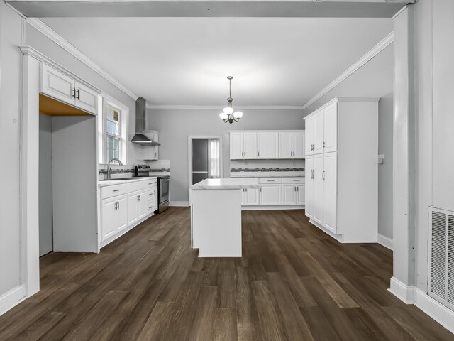 kitchen featuring white cabinets, a kitchen island, wall chimney exhaust hood, and electric stove