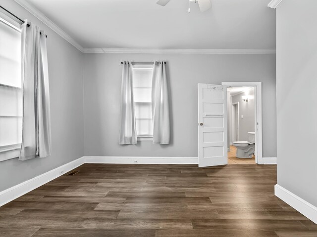 unfurnished room featuring a wealth of natural light, ceiling fan, and dark wood-type flooring