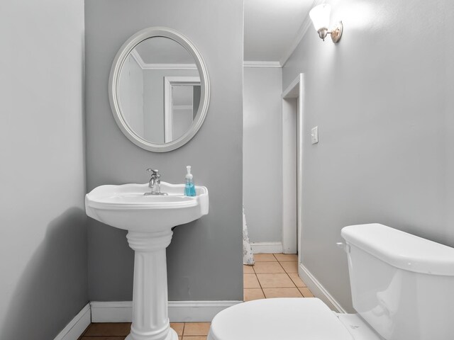 bathroom featuring toilet, tile patterned floors, and crown molding