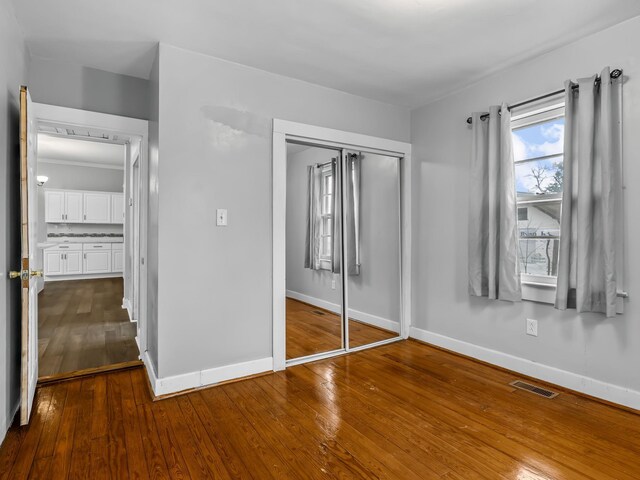 unfurnished bedroom featuring a closet and wood-type flooring