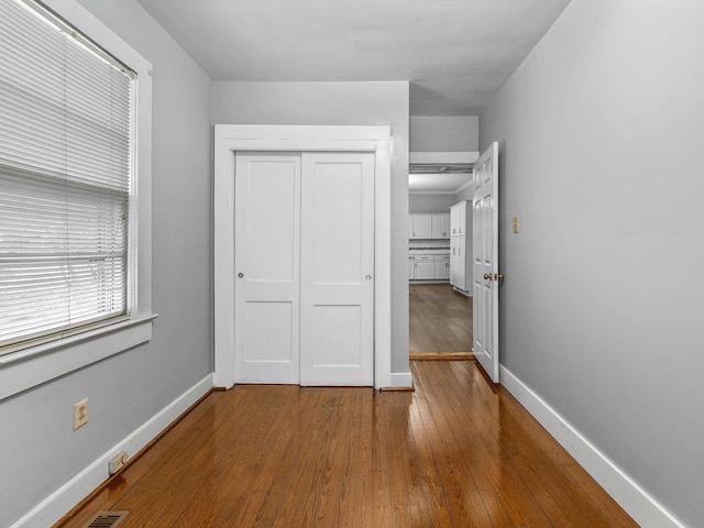 unfurnished bedroom with a closet and hardwood / wood-style floors