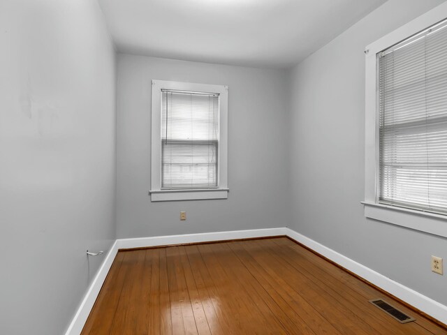 unfurnished room with hardwood / wood-style flooring