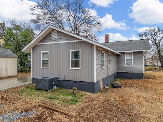 view of side of home with central AC