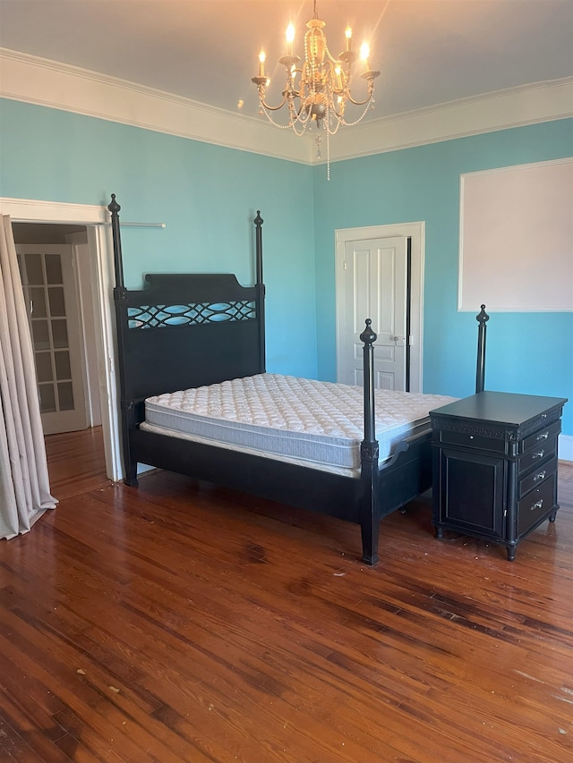 bedroom featuring crown molding, dark wood-type flooring, and a notable chandelier