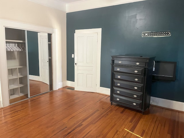 bedroom with a closet and hardwood / wood-style floors