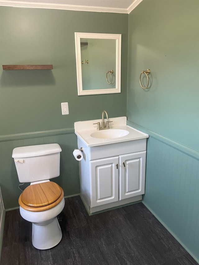 bathroom with crown molding, hardwood / wood-style floors, vanity, and toilet