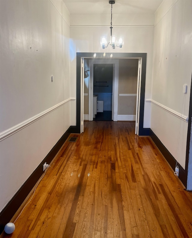 unfurnished dining area featuring a chandelier and dark hardwood / wood-style floors