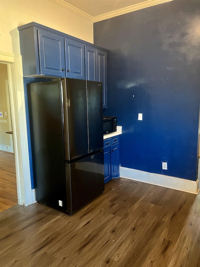 kitchen with blue cabinetry, stainless steel refrigerator, dark hardwood / wood-style floors, and ornamental molding