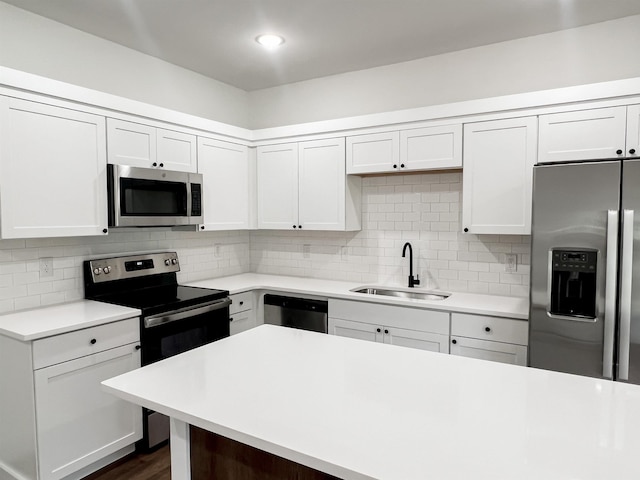 kitchen with backsplash, sink, white cabinetry, and stainless steel appliances