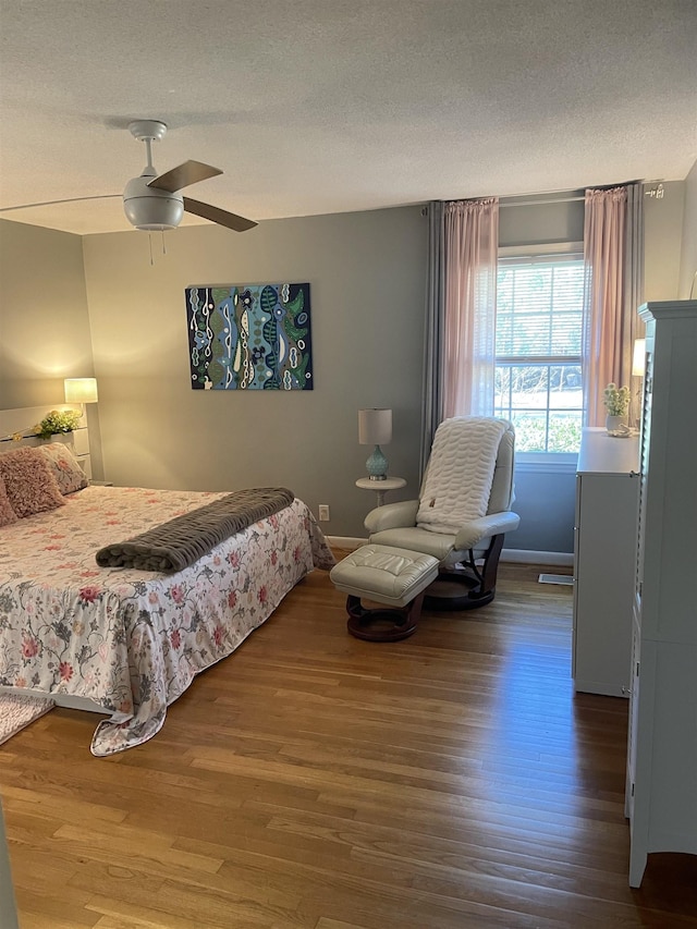 bedroom featuring ceiling fan, wood-type flooring, and a textured ceiling