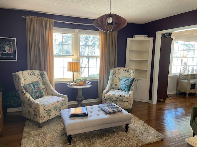 sitting room with a textured ceiling and dark hardwood / wood-style floors