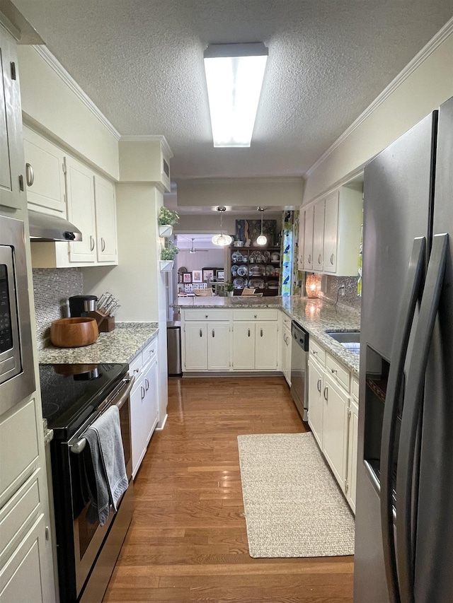 kitchen featuring a textured ceiling, white cabinets, decorative light fixtures, and appliances with stainless steel finishes