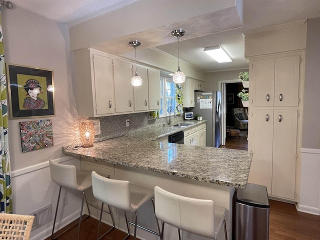 kitchen featuring tasteful backsplash, kitchen peninsula, sink, and white cabinets