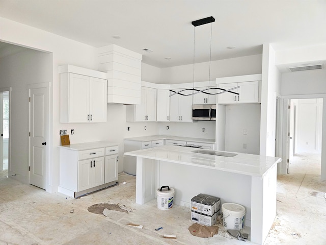 kitchen with a kitchen island, pendant lighting, and white cabinets