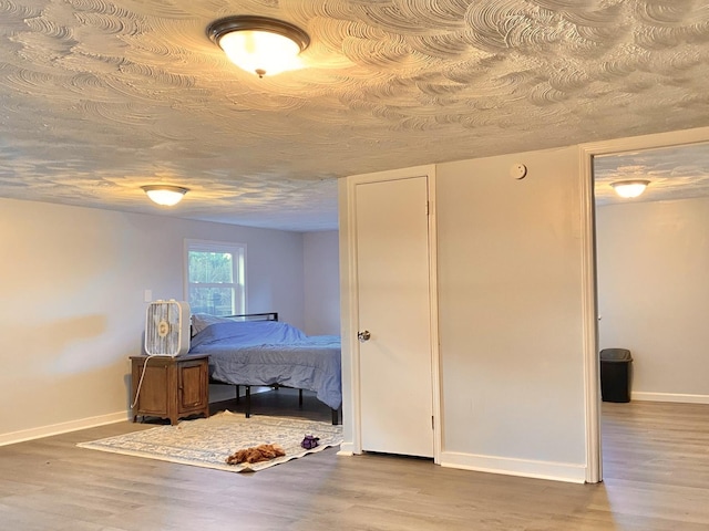 bedroom featuring wood-type flooring and a textured ceiling