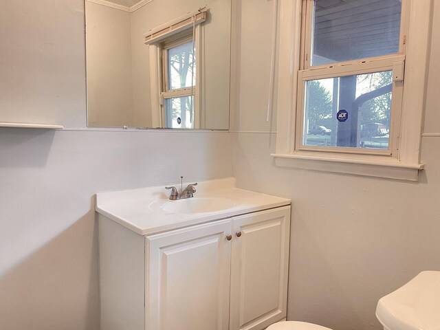 bathroom featuring vanity, toilet, and crown molding