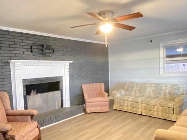 living room featuring a fireplace, light wood-type flooring, ceiling fan, and ornamental molding