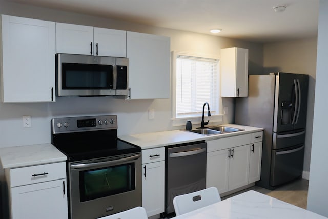 kitchen featuring white cabinetry, sink, light hardwood / wood-style floors, and appliances with stainless steel finishes