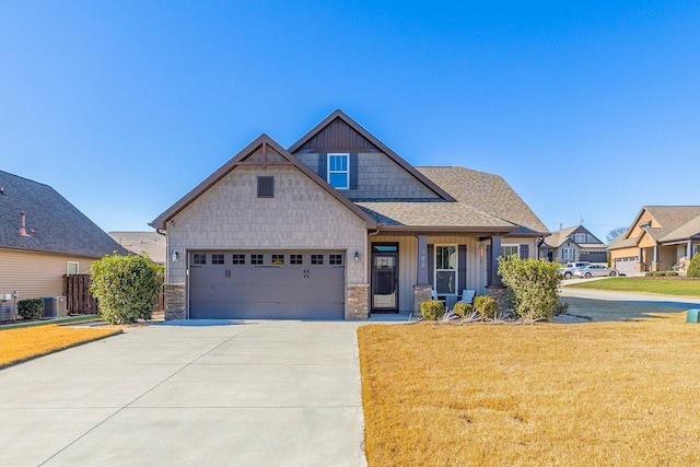 craftsman inspired home with a garage, a front lawn, and central air condition unit