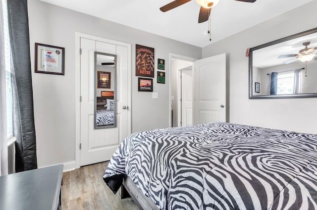 bedroom with ceiling fan, a closet, and light hardwood / wood-style floors