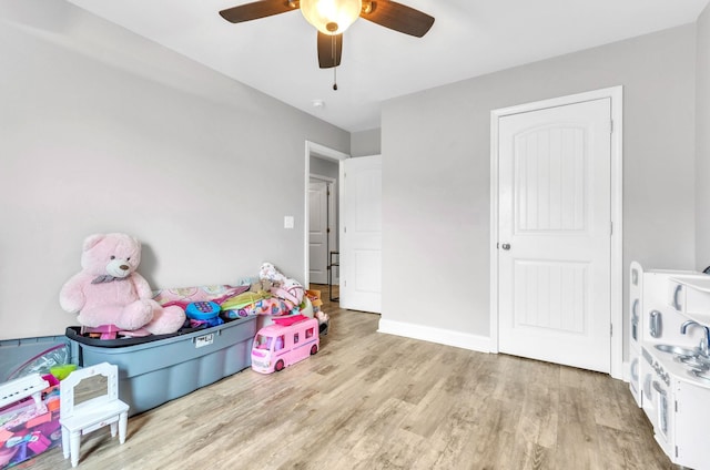 recreation room featuring light hardwood / wood-style floors and ceiling fan