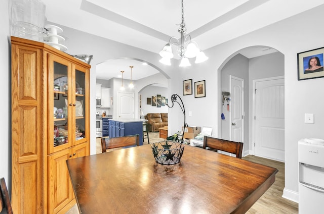 dining space featuring a notable chandelier and light hardwood / wood-style floors