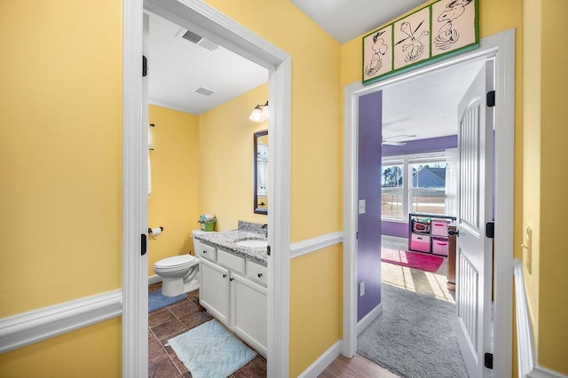 bathroom featuring tile patterned floors, vanity, ceiling fan, and toilet